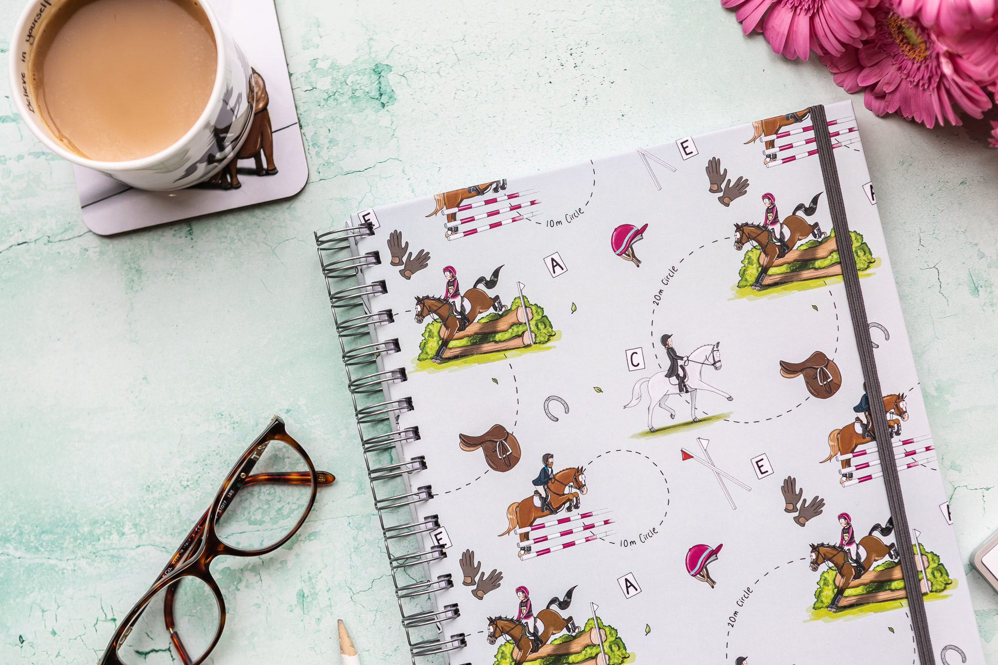 Close up of the Eventing Pattern adorned upon a hardback notebook by Emily Cole Illustrations.