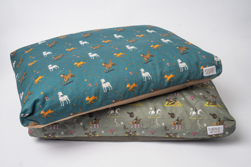 Stack of Orthopedic memory foam dog beds in green and teal with Dog pattern and Eventing Horse designs.