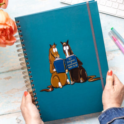 A4 hardback Notebook Two horses reading a book titled '101 expensive and inconvenient things to do'