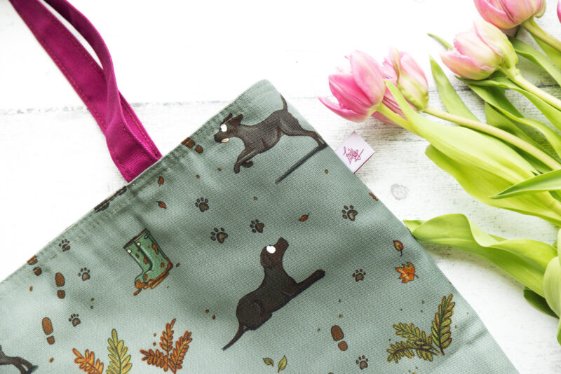 Oversized black Labrador Tote Bag by Emily Cole Illustrations. Black Labradors on a green background. Lined and zipped tote bag.