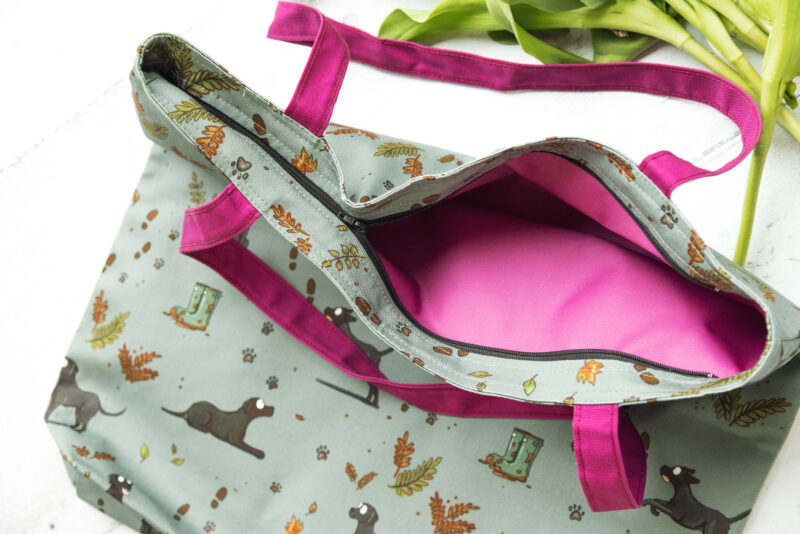 Oversized black Labrador Tote Bag by Emily Cole Illustrations. Black Labradors on a green background. Lined and zipped tote bag.