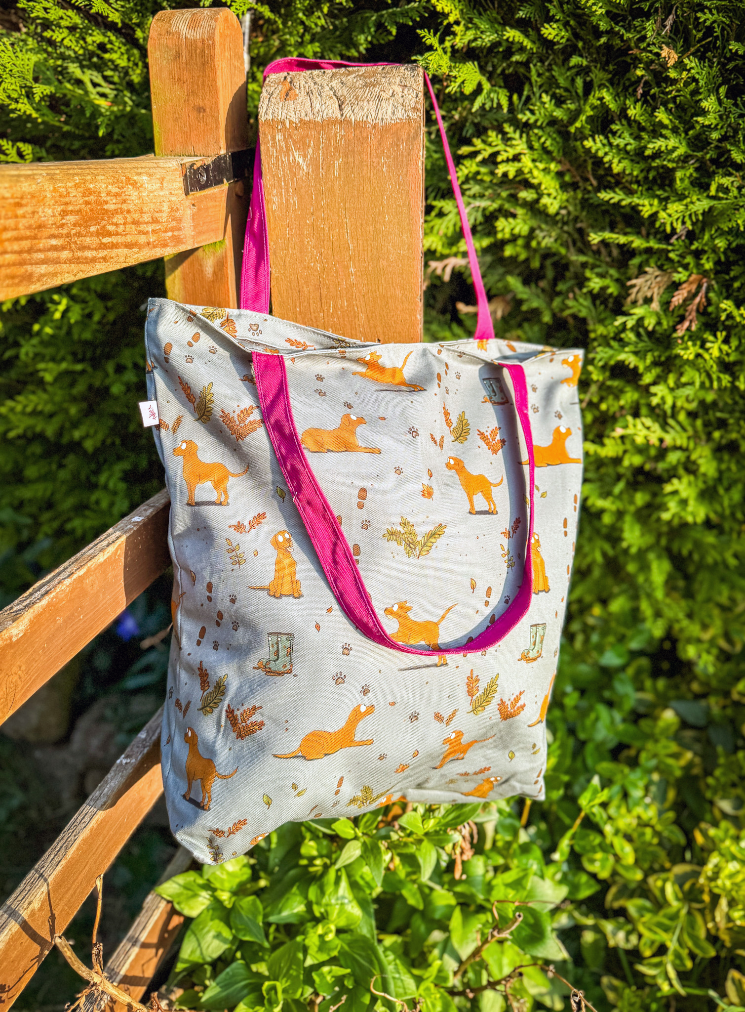 Fox red Labrador oversized tote bag with autumn leaf and paw print pattern hanging from wooden post