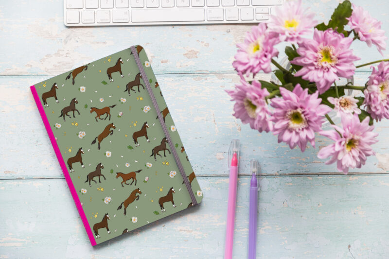 A5 soft cover notebook with bay horse pattern and pink elastic closure.