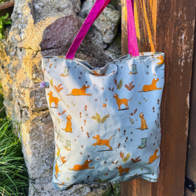 Oversized tote bag with fox red Labrador pattern hanging on wooden fence