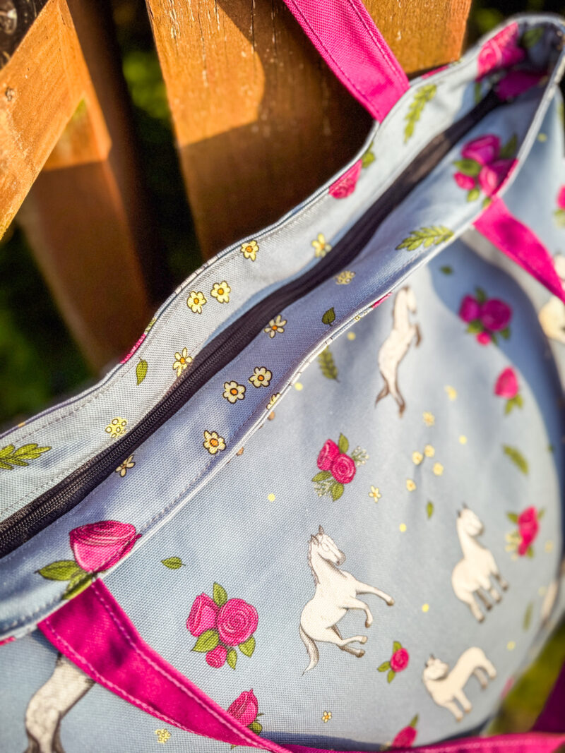 Close-up of zipped top of horse and rose patterned tote bag with floral print