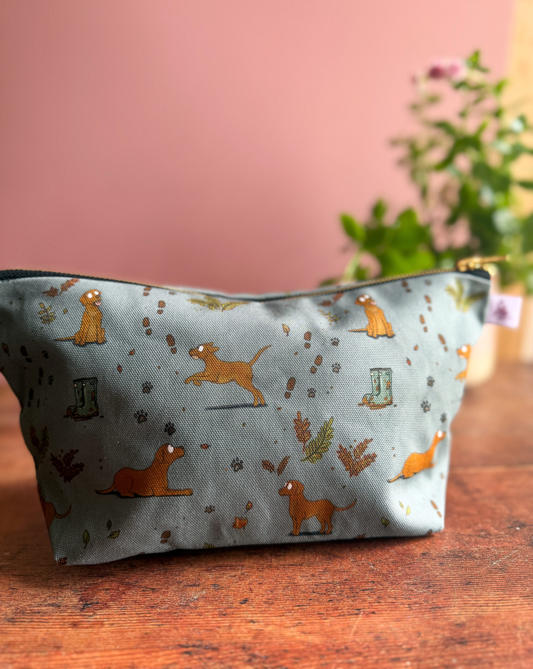 Wash bag with fox red Labrador print and muddy paw prints on a sage green background