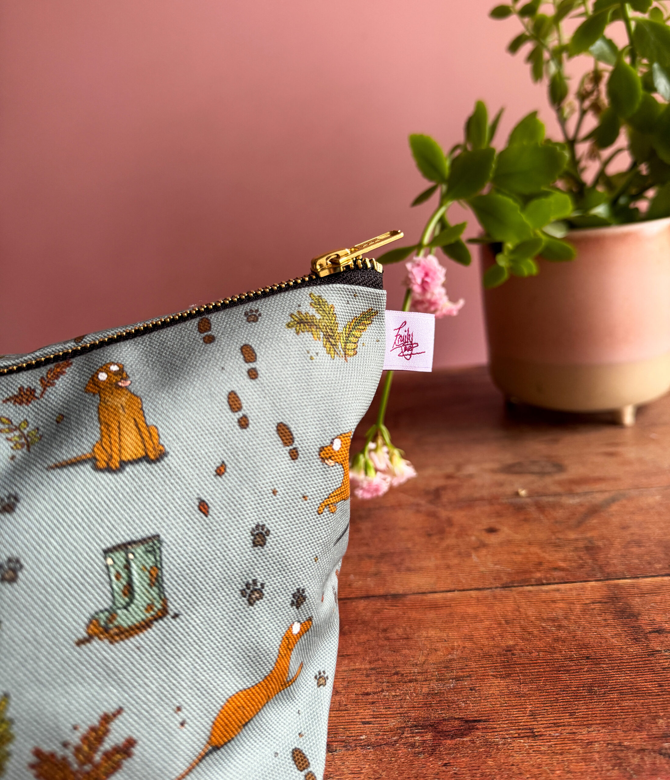 Close-up of fox red Labrador design with paw prints and autumnal leaves on wash bag