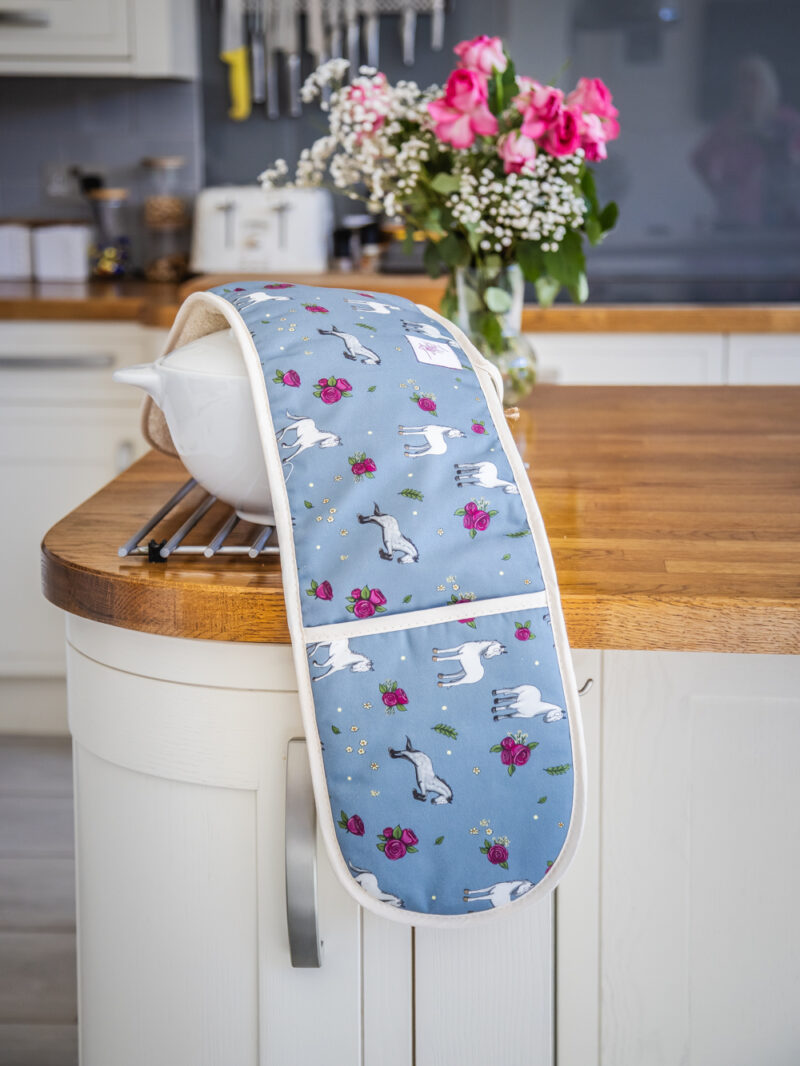 Full view of double oven gloves with Grey horse and rose pattern on blue fabric
