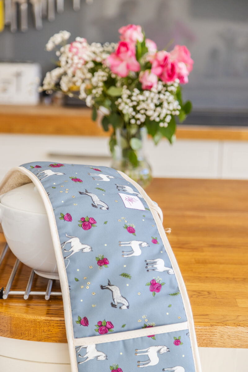 Close up image of Grey horse and rose patterned double oven gloves.