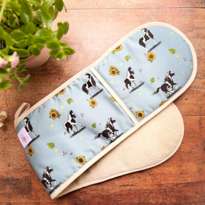 Full view of double oven gloves with piebald horse and sunflower pattern on blue fabric